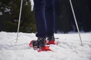 pareja divirtiéndose y caminando con raquetas de nieve foto