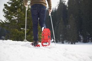 pareja divirtiéndose y caminando con raquetas de nieve foto