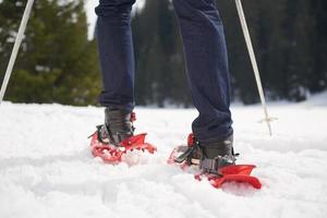 couple having fun and walking in snow shoes photo