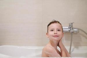 little girl in bath playing with soap foam photo