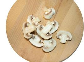 Champignons  on a cutting board. Kitchen utensils photo