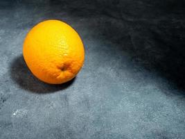 Whole orange on gray background photo