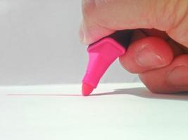 hand holding pink highlighter pen photo