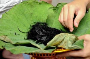 Hair on fresh lotus leaves tray from ordination of Thai monk photo