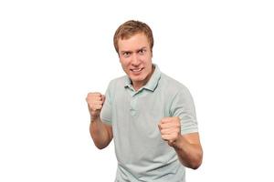 Angry young man in mint T-shirt ready to fight with fists isolated on white background photo