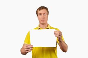 Funny attractive guy holding blank paper sheet, paper mockup isolated on white background photo