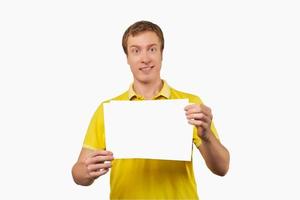 Funny attractive guy holding blank paper sheet, paper mockup isolated on white background photo