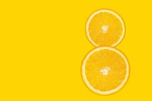 Eight digit - sliced orange, yellow background. photo