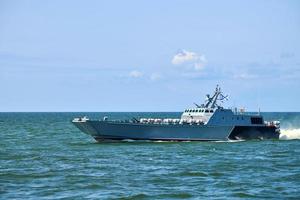 Large modern grey warship sailing in still blue sea water. International security, Russian Navy photo