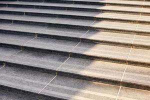 Grey stone steps in modern style, large staircase with stone-like grey texture, wide granite ladder photo