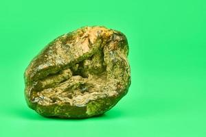 Rotten lemon, green background photo