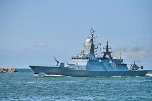 Battleship war ship boat corvette with helicopter on deck in beautiful blue sea. Navy warship photo