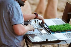 Disc jockeys DJs hands playing music on drum machine midi controller, beat sample, drum pads photo