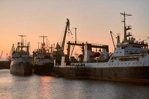 barcos en el puerto de mar en el fondo de la puesta del sol foto