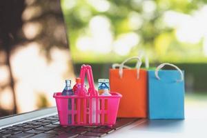 Mini shopping basket on laptop with shopping bag,Online shopping or ecommmerce delivery service concept photo