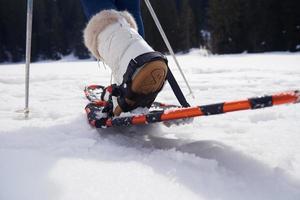 pareja divirtiéndose y caminando con raquetas de nieve foto