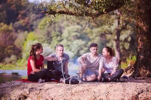 friends smoking hookah on the river bank photo