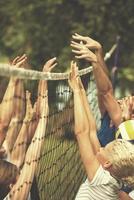 group of young friends playing Beach volleyball photo