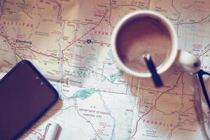 Map, map of Washington state, pen, glasses, cell phone, coffee cup on the table. photo