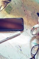 Map, map of Washington state, pen, glasses, cell phone, coffee cup on the table. photo