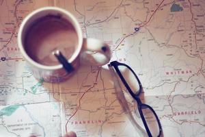 Map, map of Washington state, pen, glasses, cell phone, coffee cup on the table. photo