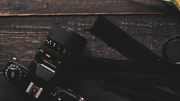 Retro film camera and negative film on a black wooden table photo