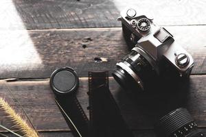 Negative film on a black wooden table and 2 vintage film cameras. photo