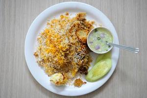 Table Top view of Indian Chicken Biryani Plate served with Egg and Potato in White Plate photo