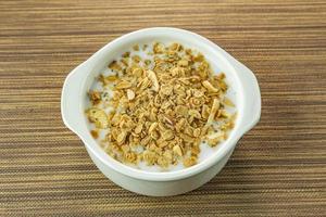 Morning food almond flakes  and milk in white bowl on wood table. photo