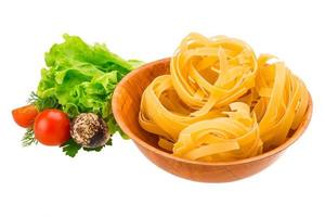 Tagliatelle in a bowl on white background photo