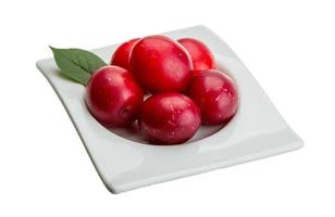 Damson plum in a bowl on white background photo