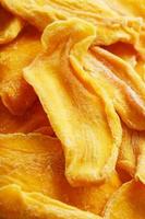 Pieces of sweet dried mango close-up as a background in full screen photo