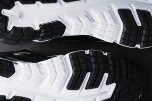 The black and white sole of trendy sports sneakers is a close-up in full screen. photo