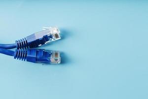 Two Ethernet Cable Connectors Patch cord cord close-up isolated on a blue background with free space photo