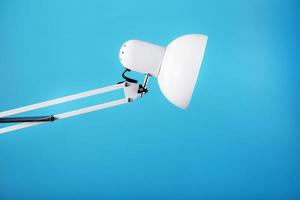 Office table lamp on blue background with space for text and idea concept photo