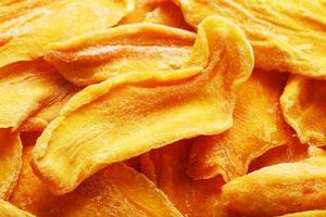 Dried sweet mango fruit slices as textural orange photo