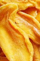 Dried sweet mango fruit slices as textural orange photo