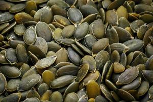 Macro background texture of green pumpkin seeds photo