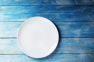 Empty round bowl on a blue wooden background from above photo