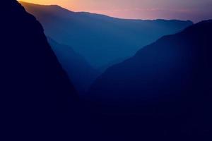 Silhouettes and outlines of a mountain massif in the setting sun photo