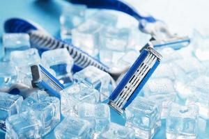 Three shaving machines on a frosty blue background with ice. The concept of cleanliness and frosty freshness photo