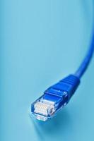 Ethernet Cable connector Patch cord cord close-up on a blue background with free space photo