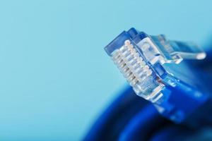 Ethernet Cable connector Patch cord cord close-up on a blue background with free space photo