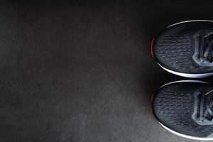 Black sports sneakers with red soles on a black background. photo