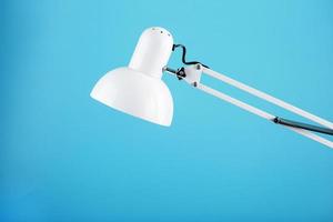 White table office lamp on blue background with space for text and idea concept photo