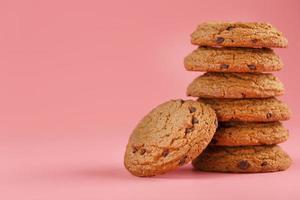 Oatmeal cookies stacked on a pink background. photo