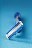 Razor blades on a blue background with drops of icy water photo