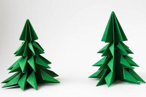 Two origami green christmas trees on white background. photo