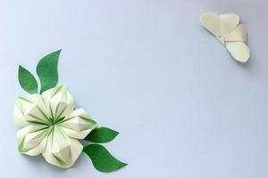 fondo de papel de origami con mariposa, flor y hojas. con lugar para texto. composición de origami. arte de papel foto