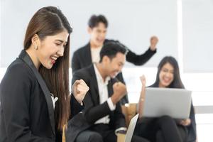 Businesspeople triumphing because of the financial growth of company. Happy smiling businesspeople triumphing with raised fists. photo